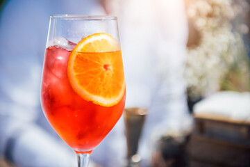 Aperol spritz cocktail in wine glass. Classic italian aperitif aperol spritz cocktail with orange and ice cubes. Close up, copy space. Summer refreshing drink with sunlight