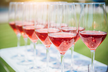 Glasses with red wine. Catering services. glasses with wine in row background at outdoor party. Shallow depth of field