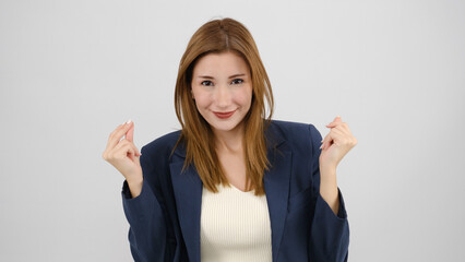 In a studio setting, a young businesswoman wearing a suit is dancing and looking at the camera in...