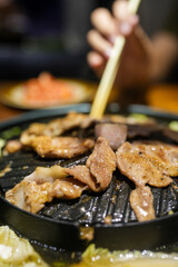 Pork or meat grilling in pan on the electronic stove. Thai barbecue buffet, Asia food,Thai call Moo ka ta. Thailand street food.