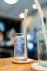 Glass of water with ice cubes, drinking water at dinner meal time at the restaurant. Selective focus