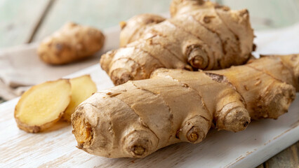 Fototapeta premium Fresh ginger root on wooden surface, showcasing its unique texture and color