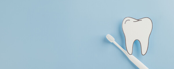 Dentist Day presents a white paper tooth model and toothbrush on blue