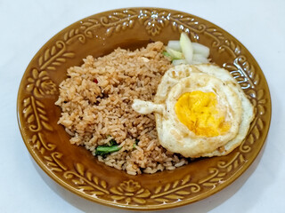 Fried rice, vegetables, crackers with fried egg as a side dish. Fried rice on a glass plate.