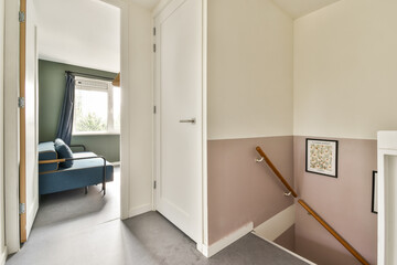 A well-lit modern interior hallway showcasing a blend of colorful walls and minimalist furniture, creating a fresh and inviting atmosphere.