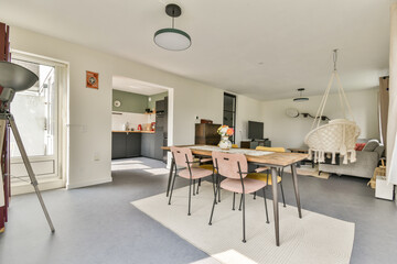A spacious, modern dining area featuring minimalist furniture, warm colors, and natural lighting, promoting a cozy atmosphere for meals and gatherings.