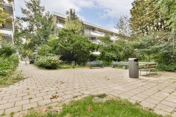 A peaceful park area featuring benches and lush greenery, creating a tranquil outdoor environment in an urban setting.