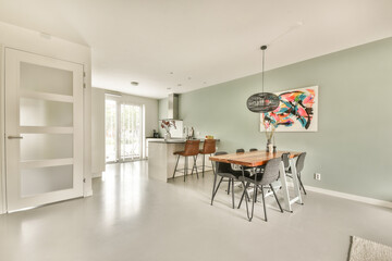 A stylish, modern interior showcases a dining area with minimalist decor, featuring a dining table and artistic wall art in a light-filled environment.