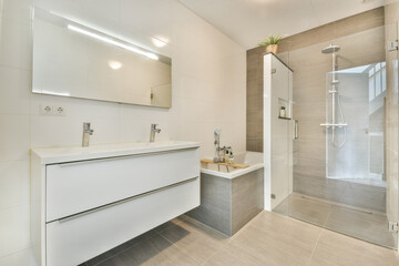Stylish contemporary bathroom featuring sleek fixtures, a spacious shower, and elegant lighting. The minimalist design enhances the overall aesthetic.