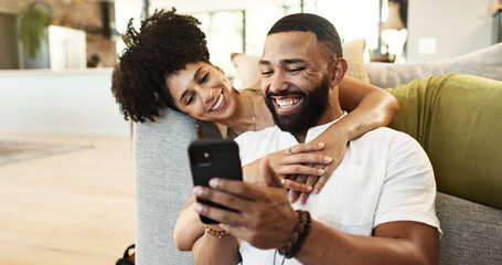 Couple, hug and laughing for phone in house with social media meme, internet joke and comic notification. People, happy and smartphone in living room with funny web search, bonding or embrace in home