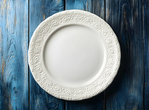 Elegant white ornate plate on rustic blue wooden table, top-down view creating a timeless and inviting culinary backdrop for food presentation and creative staging - Powered by Adobe