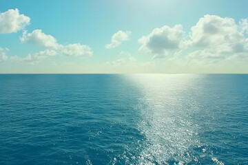 Fototapeta premium Serene ocean landscape, bright sun reflecting on tranquil blue waters under a partly cloudy sky. Perfect for travel, relaxation, and summer themes.