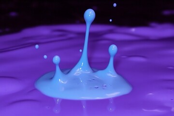 Stunning abstract close-up of a blue paint splash on a purple surface, a captivating display of color and motion.