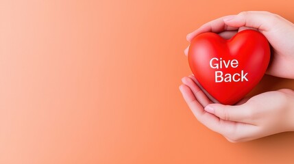 Hands Holding a Red Heart with Text Give Back on Orange Background