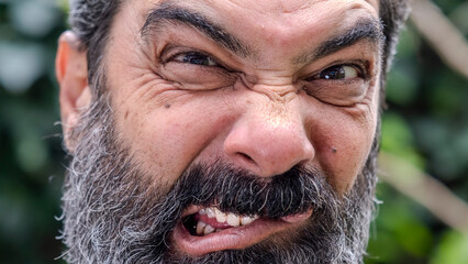 An extreme close-up headshot of a middle-aged man making funny facial expressions while looking at the camera