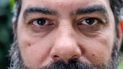 A headshot of a middle-aged man looking seriously at the camera