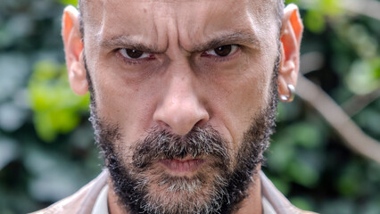 A headshot of a middle-aged man looking seriously at the camera