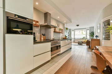 A sleek and contemporary kitchen showcases clean lines and a warm color palette. The open layout invites natural light, making it both functional and stylish.