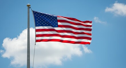 Obraz premium Majestic American Flag Waving Against a Bright Blue Sky
