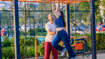 Obraz premium A slightly overweight teenage girl playing in the park with her father on a fall day