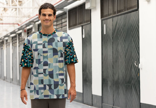 Man Showcasing Total Print Design T-Shirt in Modern Setting. Option to insert a different design on the neck, sleeves and chest and to change the color of the shirt