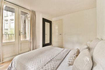 A sleek, modern bedroom featuring a minimalist design with elegant furnishings and ample natural light. The room exudes calmness and simplicity.