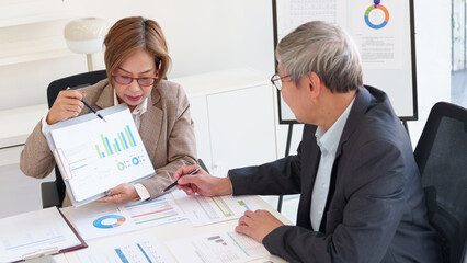 Senior business professionals discussing financial growth strategies while reviewing performance...