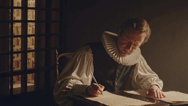 A dimly lit video scene captures a man in period attire writing at a desk, shot from a side angle, evoking a historical and contemplative mood.