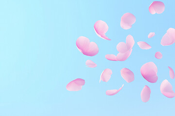 Pink flower petals float gracefully against a bright blue sky on a calm day creating a serene and peaceful atmosphere