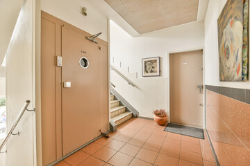 A stylish modern interior hallway featuring a staircase, decorative walls, and art pieces that enhance the aesthetic appeal of the space.