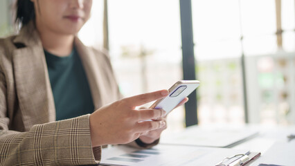 Asian Business woman using smart phone spending time checking news social media