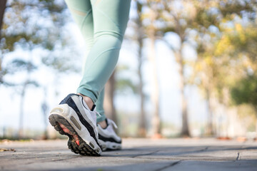 Close-up of a runner's feet running on a street in a park