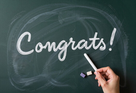 Elegant chalkboard "Congrats!" message in soft classroom lighting, celebration