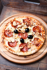 Pizza with chorizo ​​sausage, mozzarella cheese and black olives. Soft focus.