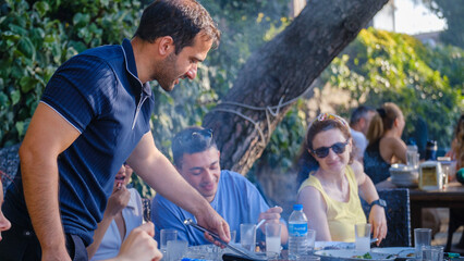 Friends barbecuing in a picnic area on a summer day