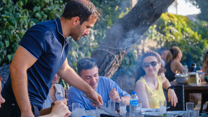 Friends barbecuing in a picnic area on a summer day