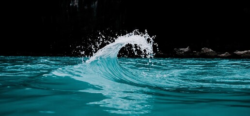 Small turquoise ocean wave curling with whitewash.