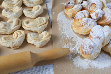 Vanilla buns. Concept - making scones.
Close-up of yeast dough for buns and finished buns with icing sugar and rolling pin on wooden table.
