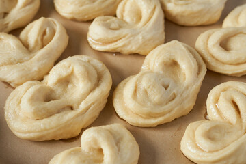 Raw dough for buns on baking paper, close-up.