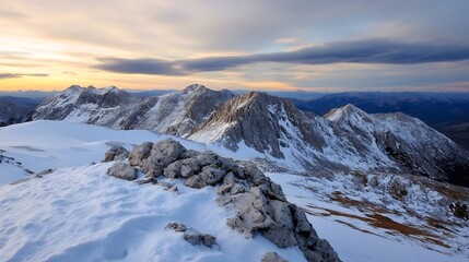 Obraz premium Stunning panoramic view of snowcovered mountains at sunset with rocky foreground showcasing nature's raw beauty : Generative AI