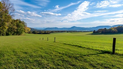 Naklejka premium Vast green meadow under a bright blue sky with gentle clouds and distant mountains in scenic view : Generative AI