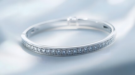 A fine platinum bracelet with embedded diamonds, resting elegantly on a white background