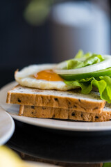 Fried yolk egg placed on whole wheat bread and fresh lettuce green oak. Breakfast concept
