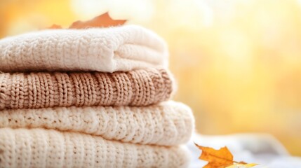 Cozy Knitted Sweaters Stack with Autumn Leaves on Soft Background : Generative AI