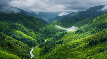 A scenic mountain view featuring a meandering river, misty valleys, lush vegetation, and an expansive sky