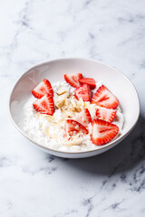 Breakfast cottage cheese with honey, strawberry and nuts.