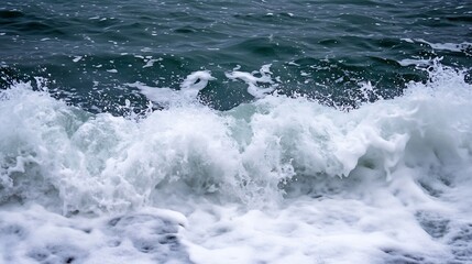 Fototapeta premium Crashing ocean waves creating foam and spray on a rocky shoreline under a cloudy sky : Generative AI