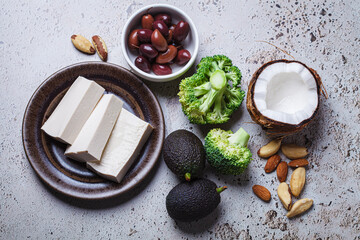 Vegan ingredients for keto diet: tofu, avocado, nuts, broccoli, coconut and olives.
