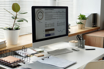 Background image of finance statistics on PC screen at minimal while office workplace copy space