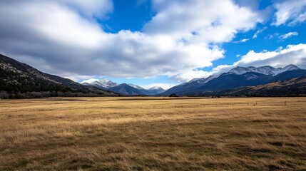 Breathtaking panoramic view of vast grassy valley with majestic mountains under blue sky : Generative AI